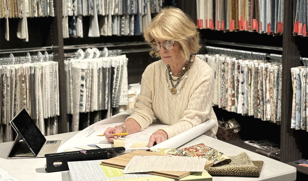 Judy Kennedy reviewing wallcovering sample books, the thrill of the hunt