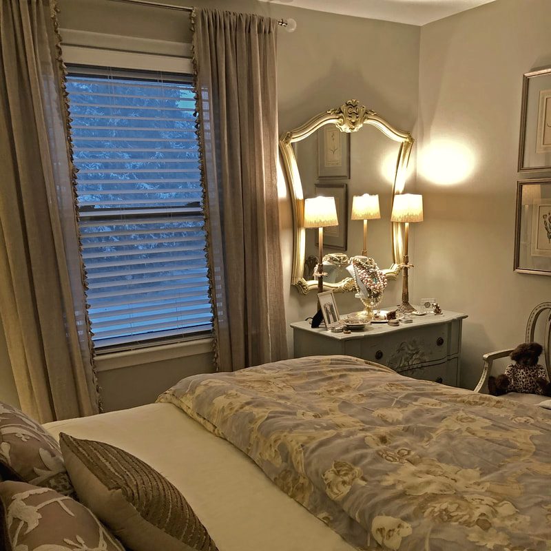 Bedroom with candle wall sconces and an upholstered bed in a moody palette