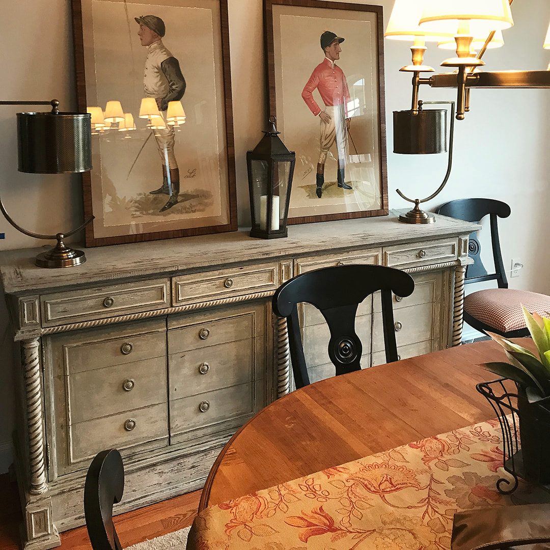 Dining room sideboard styled with paired lamps and framed equestrian art