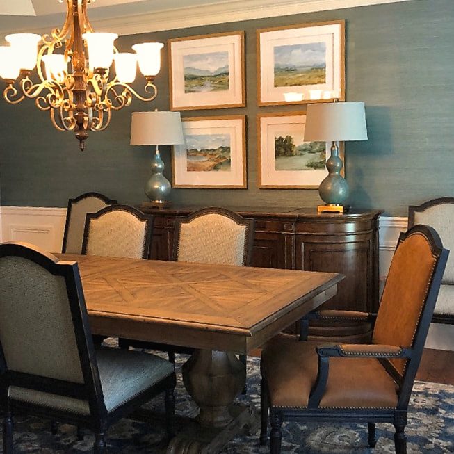 Dining room with a framed gallery wall, chandelier and blue grasscloth walls