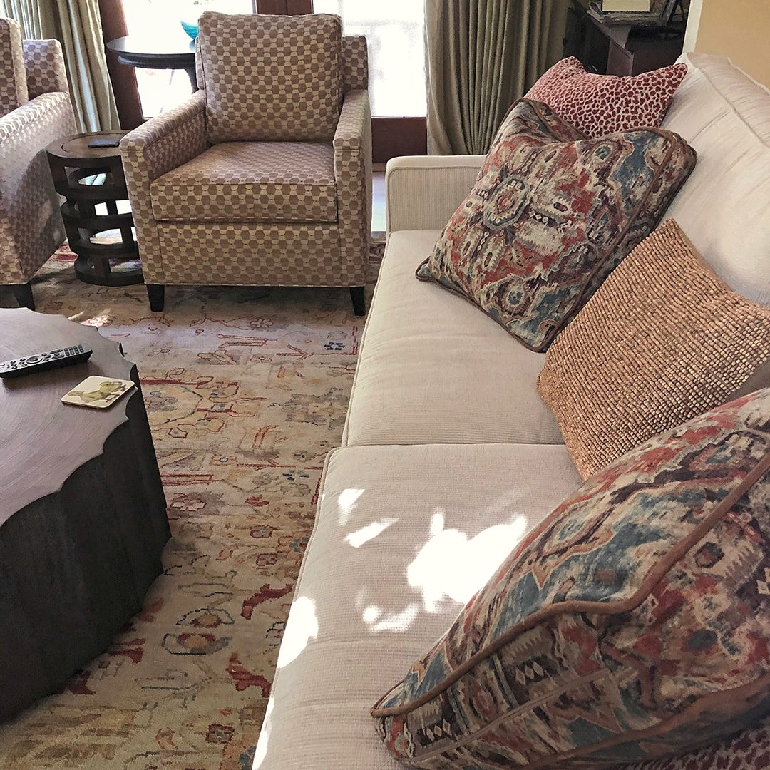 Sofa layered with patterned pillows in soft neutral and blush tones